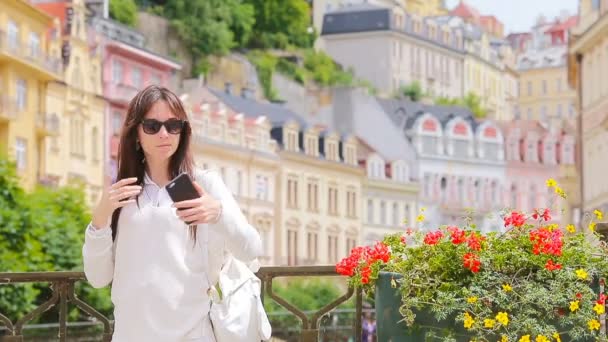 Mujer joven tomando autorretrato de fondo hermosa casa en la ciudad europea. Turista caucásica disfruta de sus vacaciones de verano europeas en Europa . — Vídeos de Stock