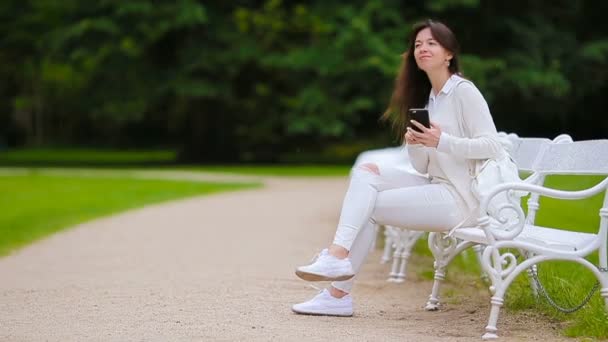 Retrato de mujer hermosa usando teléfono inteligente al aire libre . — Vídeo de stock