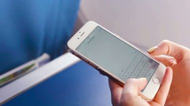 Kadın manifatura mesaj cep telefonunda. Uçak arka plan penceresi içinde closeup görüntüleme.