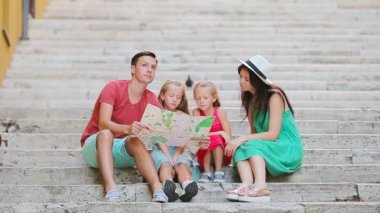 Avrupa 'da aile tatili. Aileler ve çocuklar ellerinde turistik haritayla ilgi odağı arıyorlar.