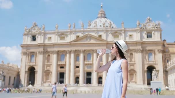Jonge vrouw drinkwater in warme dag achtergrond in St. Peters Basiliek kerk in Vaticaanstad, Rome, Italië. — Stockvideo