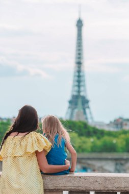 Yaz tatili boyunca Paris 'te Eyfel Kulesi' nin yanında küçük sevimli bir kız ve genç annesi.