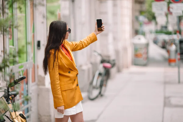 Mulher falar pelo seu smartphone na cidade. Jovem turista atraente ao ar livre na cidade italiana — Fotografia de Stock