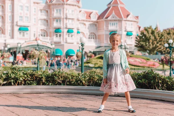 Little adorable girl in Cinderella dress at fairy-tale Disneyland park — Stock Photo, Image