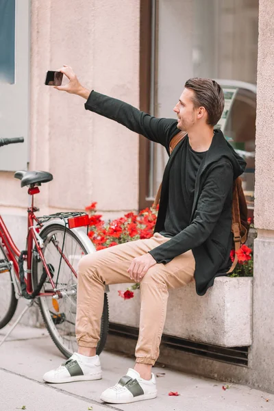 Man toerist in Europa straat. Kaukasische jongen op zoek met kaart van Europese stad. — Stockfoto