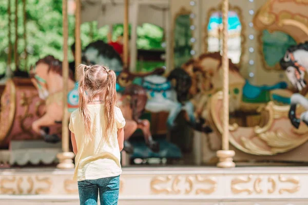 Adorabile bambina vicino alla giostra all'aperto — Foto Stock