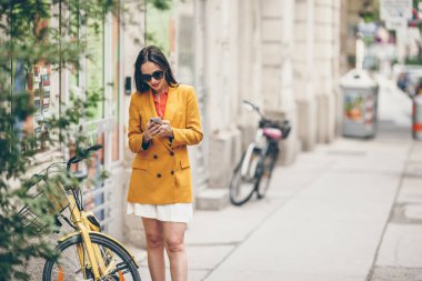 Kadın konuşmak yanında onun smartphone City. İtalyan şehri açık havada genç çekici turist