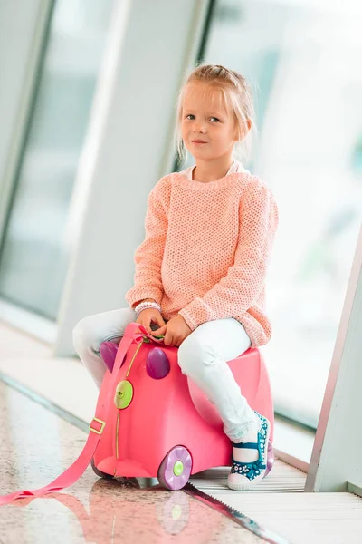 Adorable little girl in airport with her luggage waiting for boarding — Stock Photo, Image