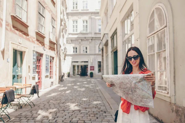 Jonge vrouw met een plattegrond van de stad in de stad. Reizen buiten toeristische meisje met kaart in Wenen tijdens de vakantie in Europa. — Stockfoto