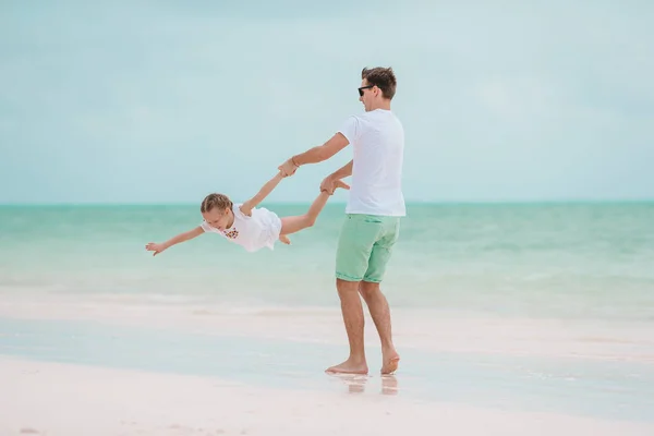 Pai feliz e sua adorável filhinha na praia tropical se divertindo — Fotografia de Stock