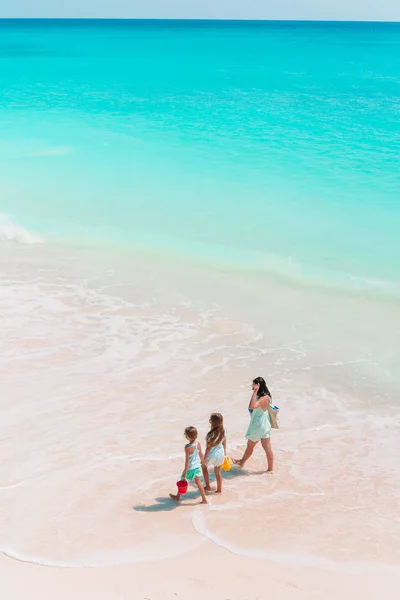 Schöne Mutter und ihre entzückende kleine Tochter am Strand — Stockfoto