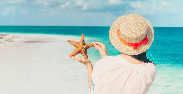 Adorabile ragazza con stelle marine sulla spiaggia — Foto Stock
