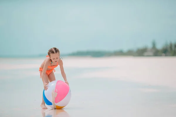 Niña adorable jugando en la playa con pelota —  Fotos de Stock