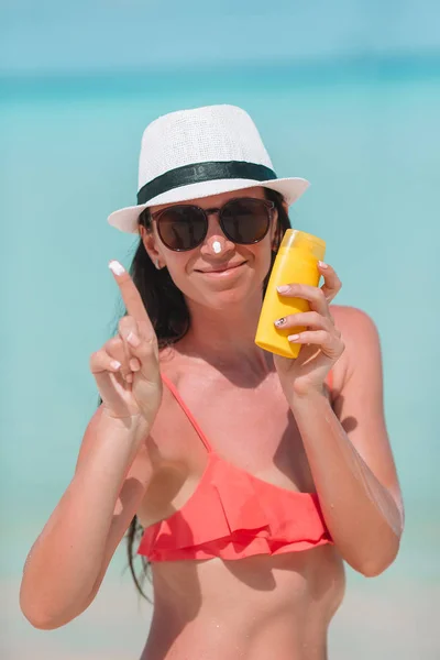 Genç kadının burnunu Beach üzerinde krem uygulamak — Stok fotoğraf