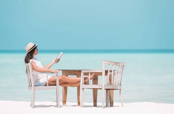 Giovane donna che legge libro durante la spiaggia tropicale maldiviana — Foto Stock