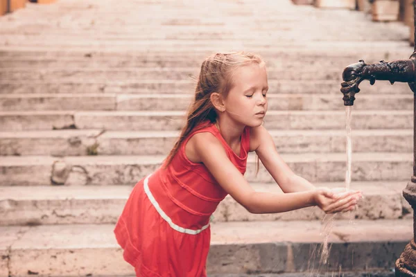 Bambina che si diverte con l'acqua potabile alla fontana di Roma — Foto Stock