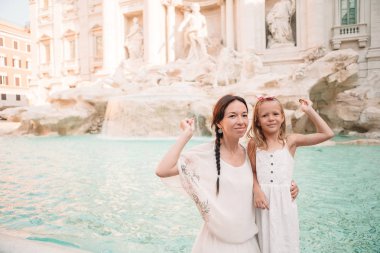 Genç güzel kadın ve Fontana di Trevi fountain yakınındaki küçük kız