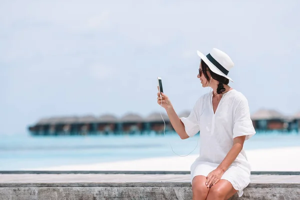 Mladá žena mluví telefonu během tropická pláž dovolená — Stock fotografie