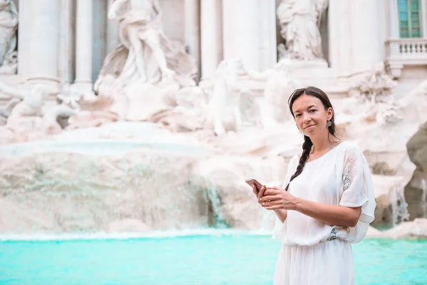 Όμορφη γυναίκα κοιτάζει στο συντριβάνι του Τρέβι κατά τη διάρκεια του ταξιδιού της στη Ρώμη, Ιταλία. Κορίτσι απολαύσετε τις διακοπές της στην Ευρώπη — Φωτογραφία Αρχείου