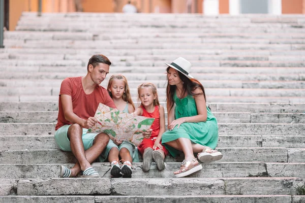 Familia feliz de cuatro en Roma con mapa —  Fotos de Stock