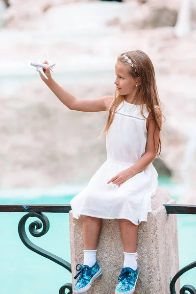グッズ飛行機背景トレビの泉、ローマ、イタリアでのかわいい女の子. — ストック写真