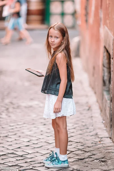 Adorabile bambina con cellulare nella città italiana durante le vacanze estive — Foto Stock