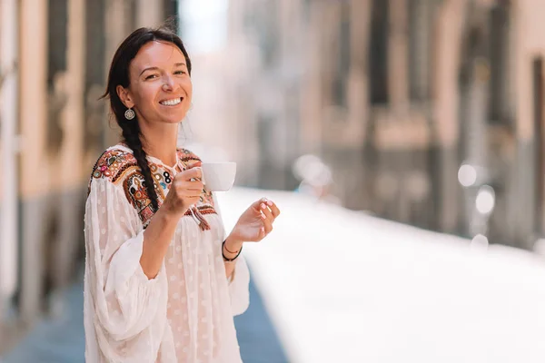 Menina caucasiana beber café quente andando na rua na Europa — Fotografia de Stock