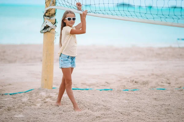 Kleines entzückendes Mädchen spielt Voleyball am Strand mit Ball. — Stockfoto