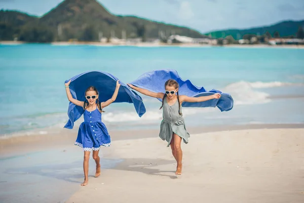 Niñas se divierten con toalla de playa durante las vacaciones tropicales —  Fotos de Stock