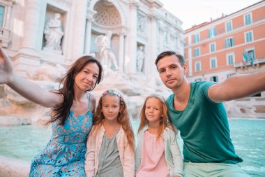 Şehir haritasıyla Fontana di Trevi yakınlarında mutlu bir aile.