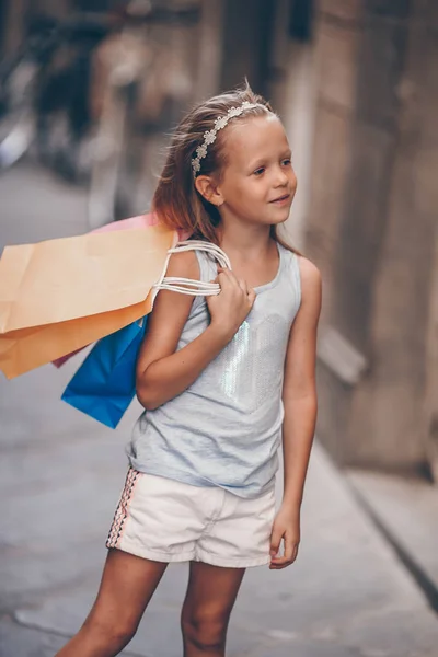 유럽 시 야외에서 쇼핑백 함께 사랑 스러운 작은 소녀의 초상화. — 스톡 사진
