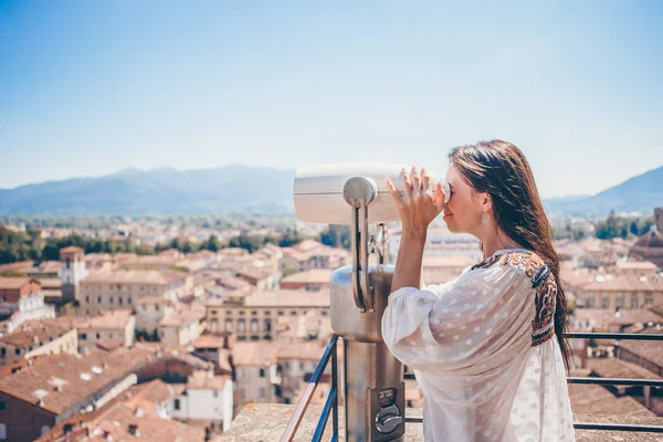 Menina olhando para moeda binocular operado no terraço na pequena cidade na Toscana — Fotografia de Stock