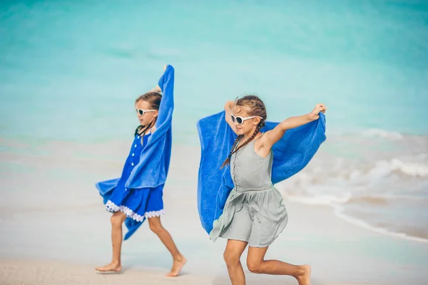 Маленькі дівчата розважаються з пляжним рушником під час тропічних канікул — стокове фото