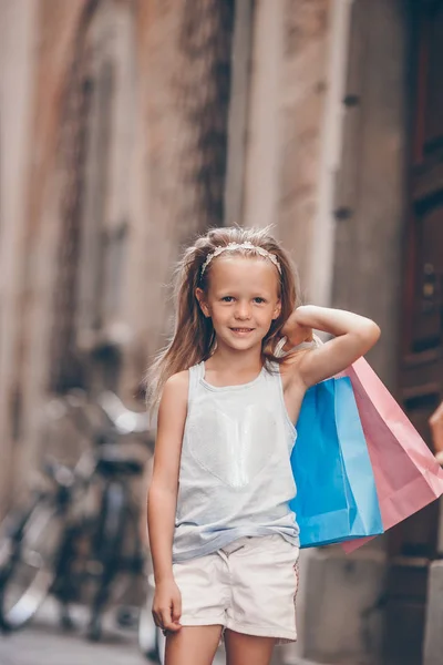 유럽 시 야외에서 쇼핑백 함께 사랑 스러운 작은 소녀의 초상화. — 스톡 사진