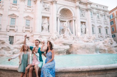Mutlu aile trowing paralar, Trevi Çeşmesi, Roma, iyi şans için. Küçük kız ve anne geri dönmek bir dilek yapma