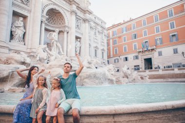 Mutlu aile trowing paralar, Trevi Çeşmesi, Roma, iyi şans için. Küçük kız ve anne geri dönmek bir dilek yapma