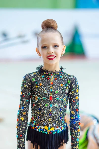 Beautiful little active gymnast girl with her performance on the carpet