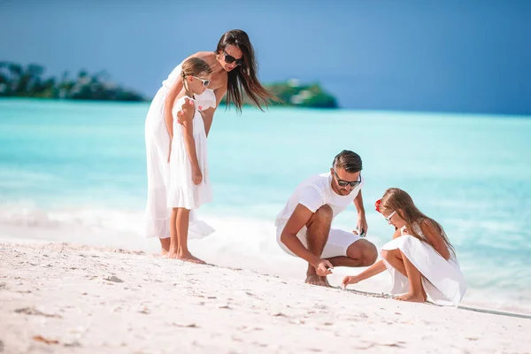 Šťastná krásná rodina s dětmi na pláži — Stock fotografie