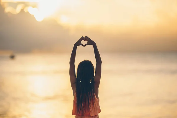 Silhouette di cuore fatta da bambini mano al tramonto — Foto Stock