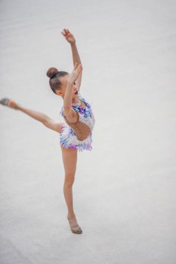Halıda performansı olan küçük, güzel, aktif bir jimnastikçi kız.