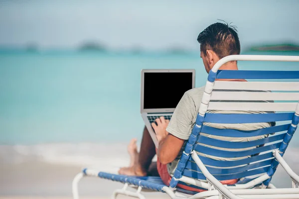 Ung man med surfplatta under tropisk strand semester — Stockfoto