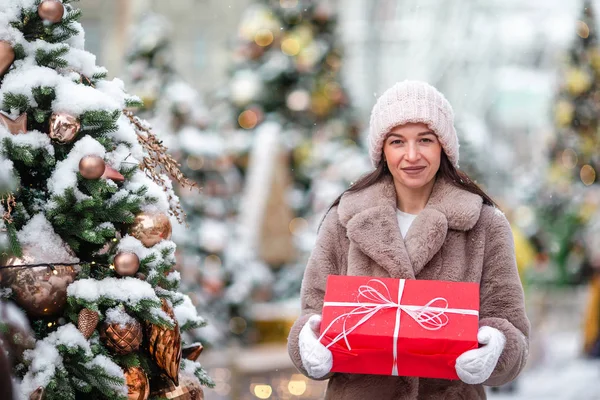 La muchacha feliz cerca de la rama del abeto en la nieve para un nuevo año. —  Fotos de Stock