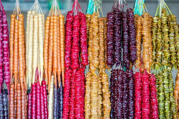 Multicolor delicioso fresco georgiano dulces Churchkhela colgando en el mercado — Foto de Stock