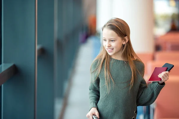 Adorable niña en el aeropuerto en el gran aeropuerto internacional cerca de la ventana —  Fotos de Stock