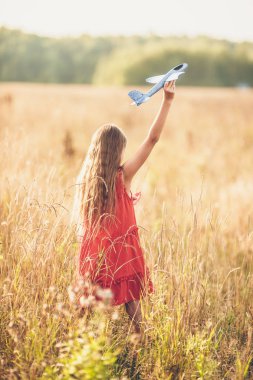 Hızlı koşan ve uçak oyuncağı tutan kız.