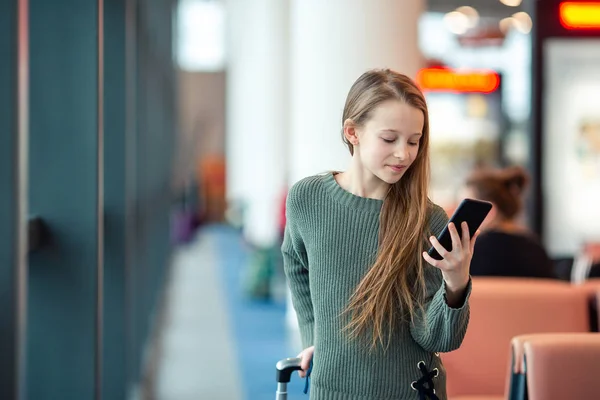 Schattig klein meisje op de luchthaven in grote internationale luchthaven in de buurt van venster — Stockfoto