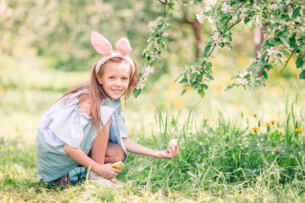 Liebenswertes kleines Mädchen im blühenden Apfelgarten an einem schönen Frühlingstag — Stockfoto