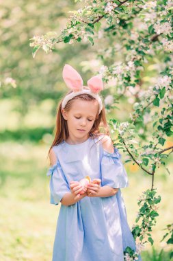 Çiçekli elma bahçesinde küçük sevimli bir kız güzel bir bahar günü