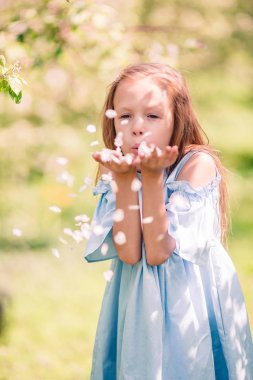 Çiçekli elma bahçesinde küçük sevimli bir kız güzel bir bahar günü