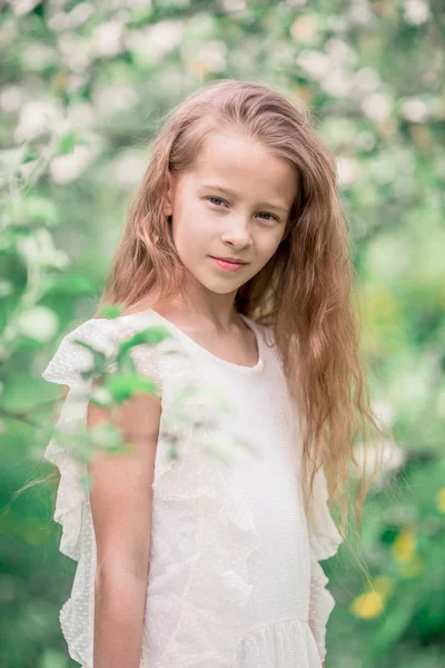 Adorable niña en el jardín de manzanas en flor en hermoso día de primavera —  Fotos de Stock